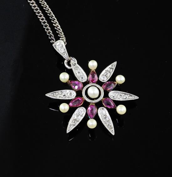 An Edwardian gold and silver, ruby, diamond and seed pearl flower head pendant, 26mm.